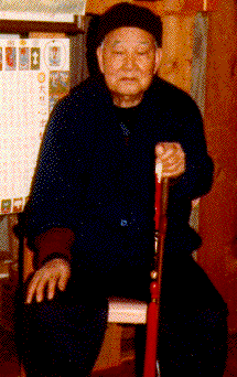 Master Liang sitting with wooden sword