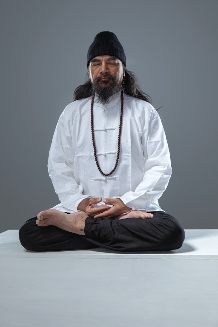 Man Dressed in Traditional Chinese Clothing Meditating in the Lotus Position